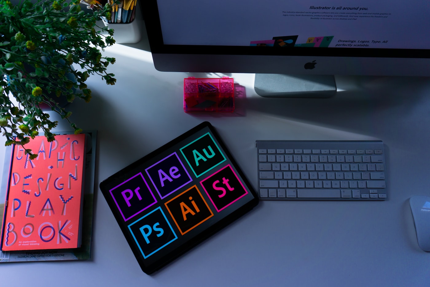 A designer sketching wireframe layouts on paper next to a laptop and color swatches